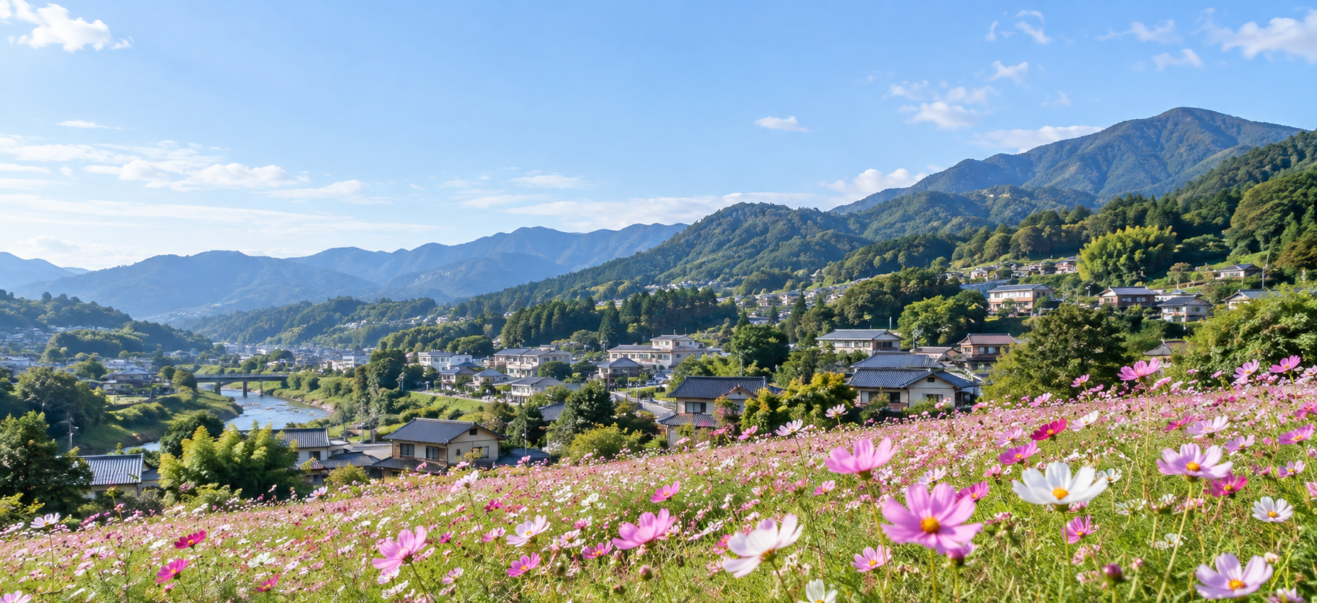 コスモス畑と山並み、街並みが調和する地域のイメージ