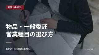 机を挟んで資料を確認する二人の手元。物品・一般委託の営業種目の選び方の見出し入り