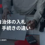 書類や電卓が置かれた事務机。国と自治体の入札資格・手続きの違いの見出し入り