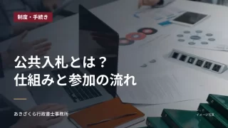 パソコンと書類が置かれた会議テーブル。公共入札の仕組みと参加の流れの見出し入り