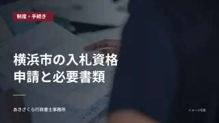 事務机で書類を確認する人。横浜市の入札資格申請と必要書類の見出し入り