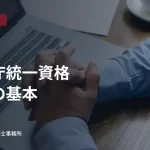 パソコンとノートを前に資料を確認する人。全省庁統一資格の申請の基本の見出し入り